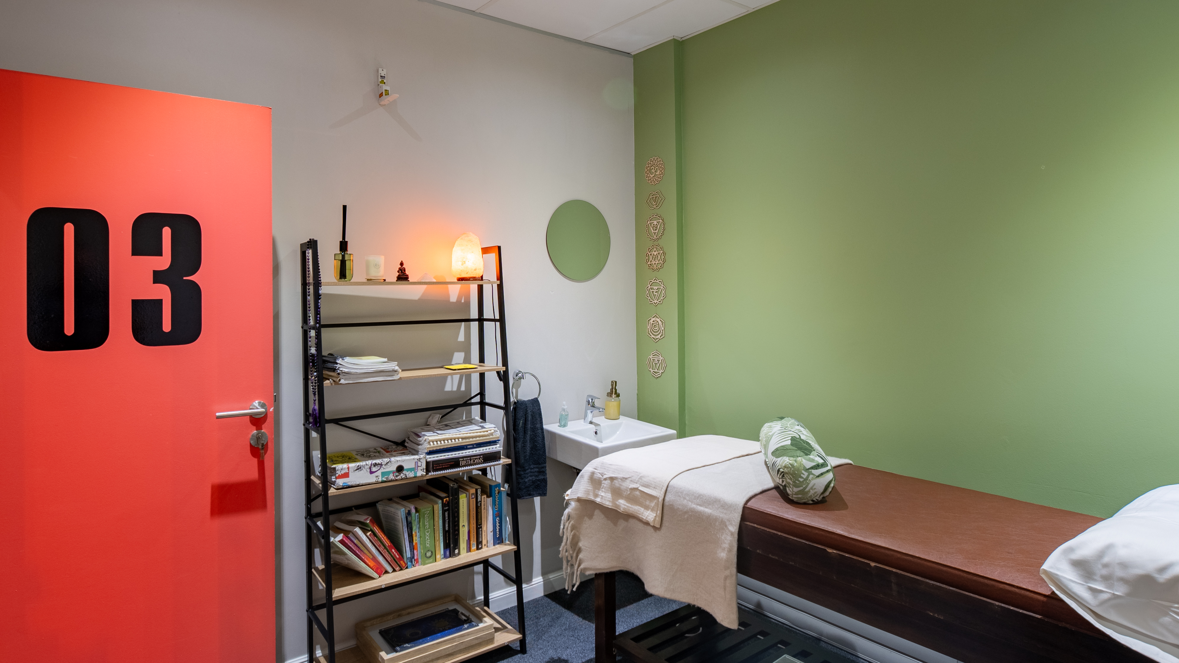 The calm Kinesiolign consulting room with its treatment table and red door