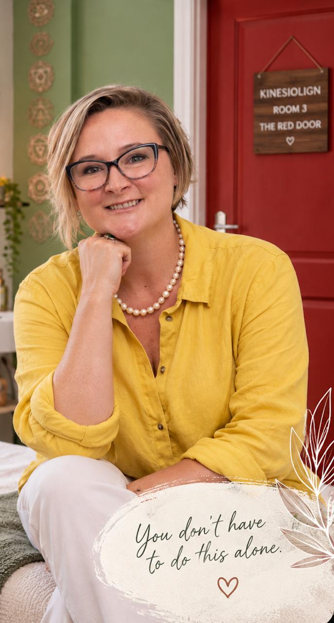 Stacey Curry smiling beside the red door of her consulting room