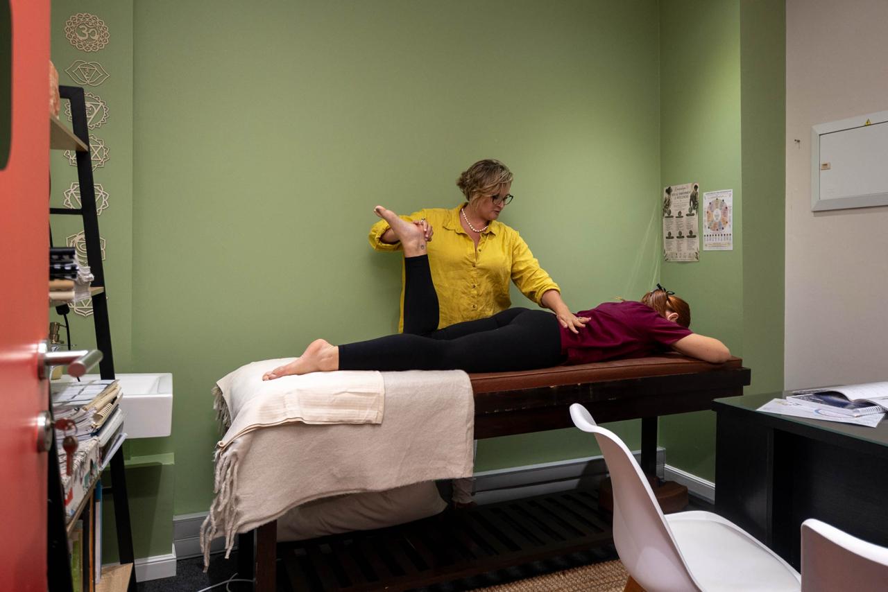 Stacey carrying out a gentle leg muscle test with a fully clothed client